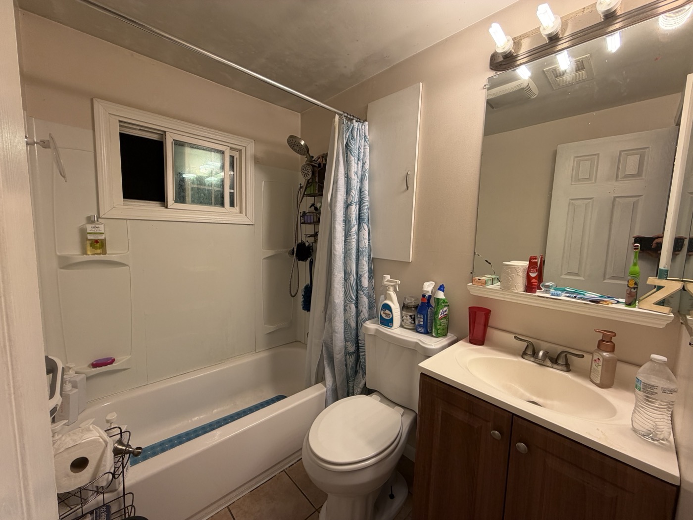 Bathroom before — dated tub and shower curtain